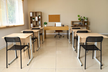 Interior of empty classroom with desks and chairs at school