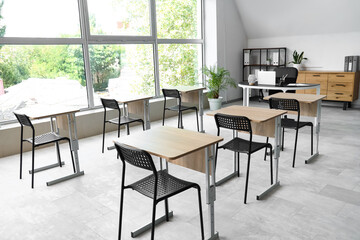 Desks and chairs in empty classroom at school