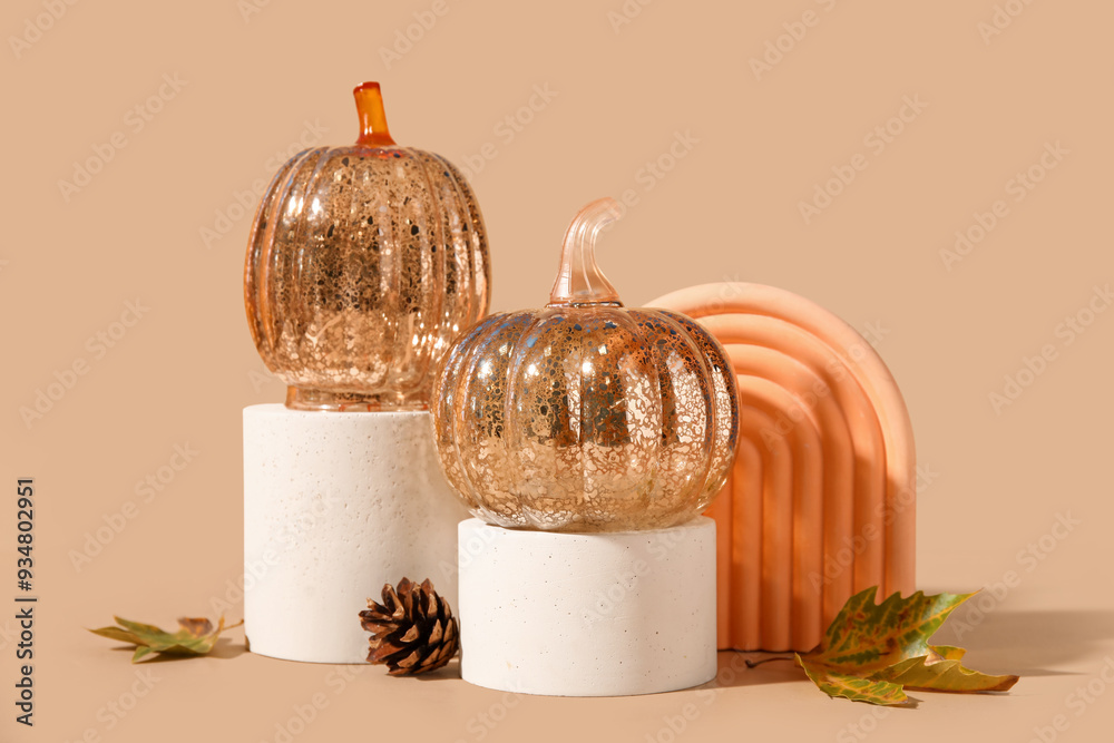 Wall mural Podiums with decorative pumpkins and autumn leaves on beige background