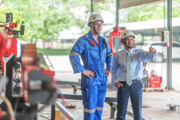 asian managers and young caucasian engineers inspecting the robots before delivery to customers