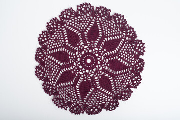 Dark red crochet doily on a white background