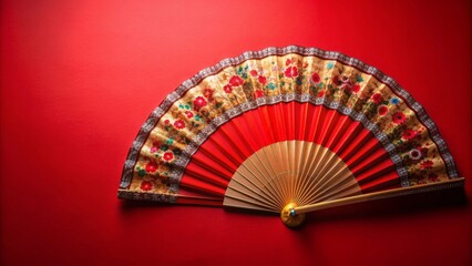 Chinese folding fan with intricate design on vibrant red background