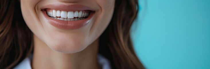 Fototapeta premium A close up portrait of a smiling woman with perfect teeth against a vibrant blue background conveying beauty and confidence