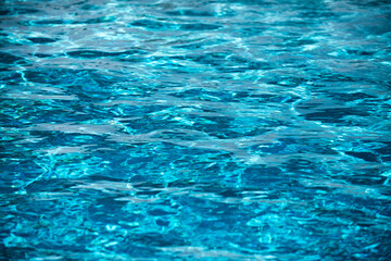 Ripped water in swimming pool. Surface of blue swimming pool, background of water.