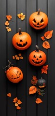 A collection of carved Halloween pumpkins surrounded by autumn leaves on a dark background. Perfect for seasonal decoration.