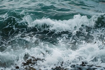 Fototapeta premium Ocean waves crashing on rocky shore with white foam.