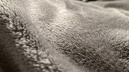 Close-up of soft gray blanket in sunlight 