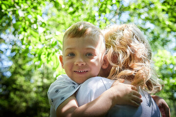 Tender Moment Between Mother and Child in a Sunlit Forest