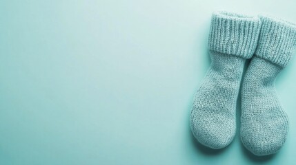 A Pair of Gray Woolen Socks on a Turquoise Background
