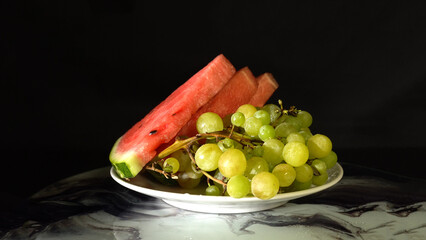 Watermelon Slices and Ripe Green Grapes on a Plate