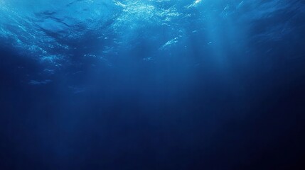 Deep Blue Abyss: Sunbeams pierce the surface of a deep blue ocean, illuminating the depths below. 