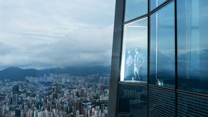 Successful businessman in suit standing in office looking through window at big city buildings