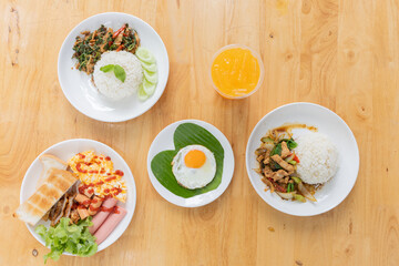Colorful and appetizing meal spread featuring rice, various dishes, and a refreshing drink on a wooden table.