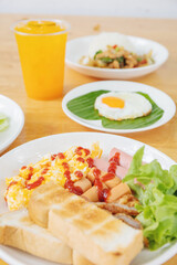 Detailed Breakfast Plate: Toast, Egg, Salad, and a Refreshing Orange Drink, Accompanied by a Parfait for a Well-rounded Morning Meal