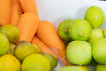 Fresh carrots and green apples create a vibrant and healthy display, perfect for showcasing natural produce indoors.