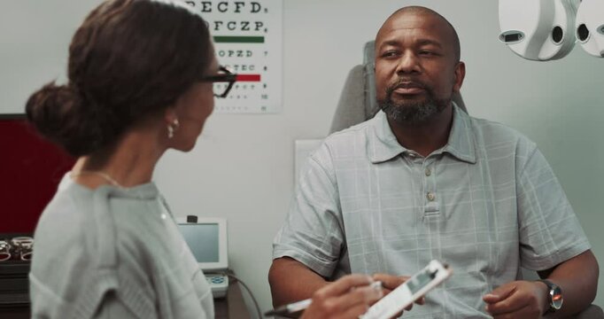 Healthcare, woman and talking to man, optician and question for sight in hospitality, notes and clipboard. Medical appointment, listening and person with doctor for vision, consultation and test