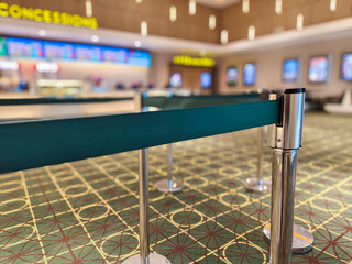 selective focus on green barrier tape used to organize queue of people