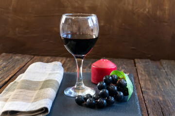 Red Wine Glass and Grape Bunch on a Wooden Table