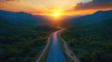 photo of a narrow winding asphalt wet road in a mountainous area at sunset. Top view.