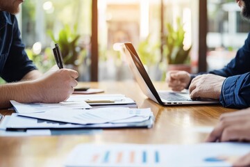 A coach and a client work together at a conference table, with business documents and a laptop between them The atmosphere is focused