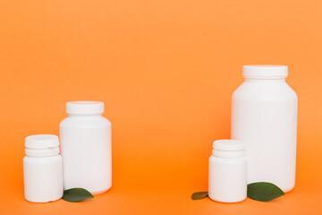supplement pills with medicine bottle health care and medical top view. Vitamin tablets. Top view mockup bottle for pills and vitamins with green leaves, natural organic bio supplement, copy space