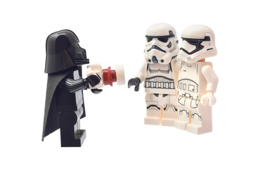 Obraz premium Lego minifigure of Darth Vader is taking a picture of two soldiers. Editorial illustrative image of popular children plastic bricks Star Wars. 