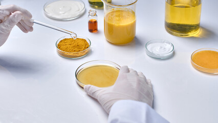 Template photo for cosmetic advertising, which extracted from natural ingredients like turmeric. Cosmetic research in laboratory from high angle shot with plenty lab glassware placed on white table