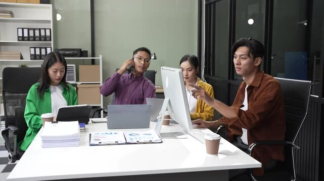 In a boardroom, an Asian team discusses startup financials and business terms. They present strategies on acquisitions, cash flow, and investor relations, innovative approaches for company growth.
