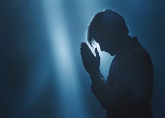 Silhouette of person kneeling in deep prayer, surrounded by ethe