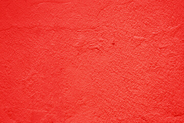 Fototapeta premium The surface of an old, rough concrete wall is red.