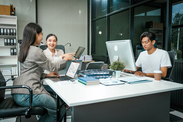 Asian colleagues meet at a desk, discussing business financial terms, investment strategies,...