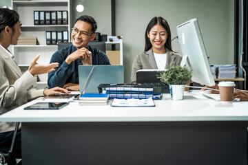 Asian colleagues meet at a desk, discussing business financial terms, investment strategies,...