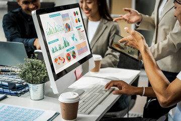 Asian colleagues meet at a desk, discussing business financial terms, investment strategies,...