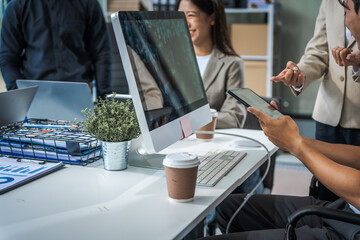 Asian colleagues meet at a desk, discussing business financial terms, investment strategies,...