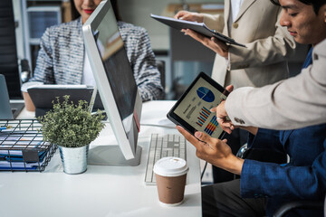 Asian colleagues meet at a desk, discussing business financial terms, investment strategies,...