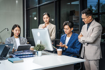 Asian colleagues meet at a desk, discussing business financial terms, investment strategies,...