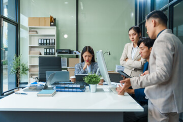 In an office, stressed Asian colleagues discuss financial failures at a desk. business finance, investment strategies, risk management, operational responsibilities to recover stability and success.