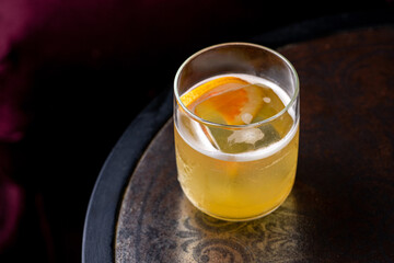 Satsuma cocktail in glass on dark background