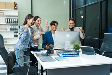 In an office, an Asian team meets at a desk, analyzing financial data on a monitor. They discuss business finance, operational guidelines, and strategies for success, data-driven decision-making.