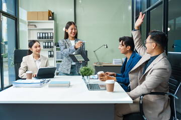 In a boardroom, an Asian team meets at a desk, presenting financial terms and strategies. Executives and employees collaborate, sharing ideas and work guidelines for success during an annual meeting.