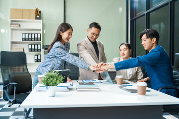 In a boardroom, an Asian team meets at a desk, presenting financial terms and strategies. Executives and employees collaborate, sharing ideas and work guidelines for success during an annual meeting.