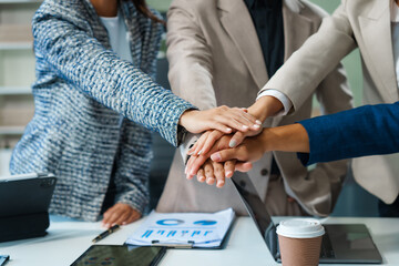 In a boardroom, an Asian team meets at a desk, presenting financial terms and strategies. Executives and employees collaborate, sharing ideas and work guidelines for success during an annual meeting.