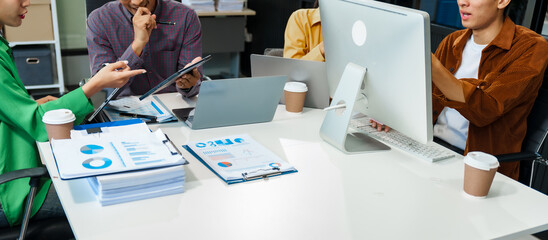 In a boardroom, an Asian team discusses startup financials and business terms. They present...