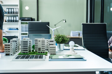 A miniature city model on a desk showcases sustainable technology, with wind turbines and solar panels. renewable energy, eco-friendly architecture, and the future of green urban development.