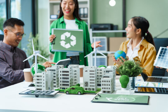 Colleagues in formal suits meet at desk to brainstorm environmental management strategies. discuss carbon emissions, renewable energy, sustainable business practices to reduce corporate footprint.