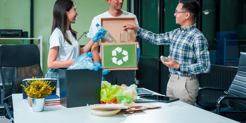 In an office, an Asian team discusses waste management strategies at a desk, separating plastic...