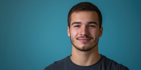 Fototapeta premium A studio close-up portrait of a young white man wearing a casual t-shirt, with a colourful background.