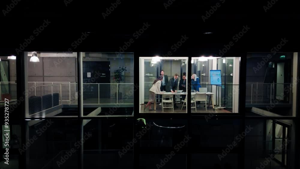 Poster manager walking into the meeting room to participate in a presentation with board members late in th