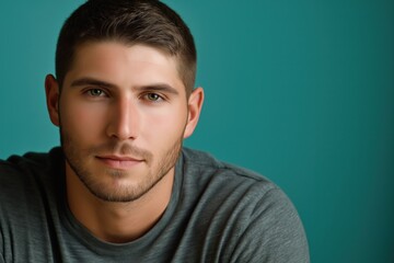 Obraz premium A studio close-up portrait of a young white man wearing a casual t-shirt, with a colourful background.