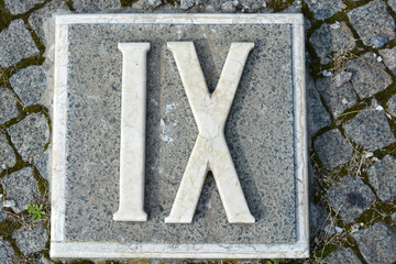 Building materials, memorials, beautiful, white inscriptions in gray and brown granite in the form of Roman numerals one, two, three, four, five, six, seven, eight, nine and ten.